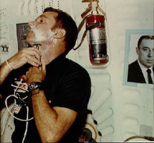 A photo of George Abbey adorns the space shuttle Columbia in 1981, watching over shaving astronaut Joe Engle.