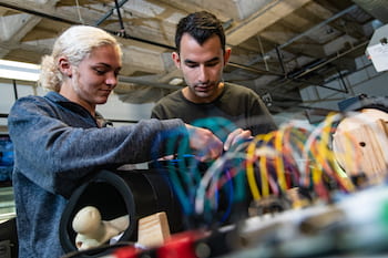 Hannah Jackson and Will Yarinsky, senior engineering students at Rice University, make an adjustment to their device to help doctors secure rods that keep fractured bones in alignment as they heal. (Credit: Jeff Fitlow/Rice University)