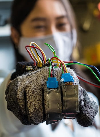 Rice University graduate student Linda Liu models the prototype glove to help reward the positive behaviors of people with trichotillomania, the compulsive pulling of hair. Photo by Jeff Fitlow
